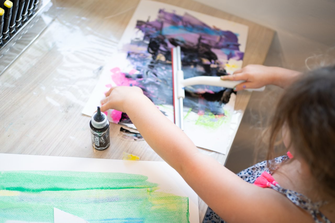 A young person painting at the studio art table