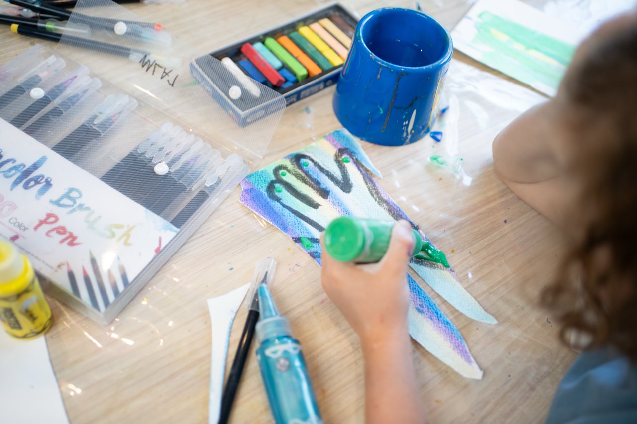 A child painting with bright green paint